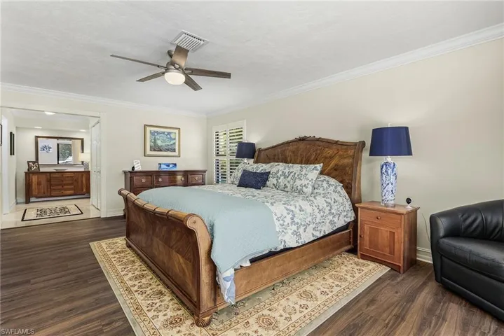 Master Bedroom featuring dark wood-type flooring, crown molding, a textured ceiling, and ceiling fan