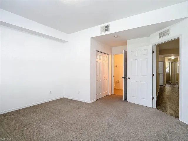 Unfurnished bedroom featuring a closet and dark carpet