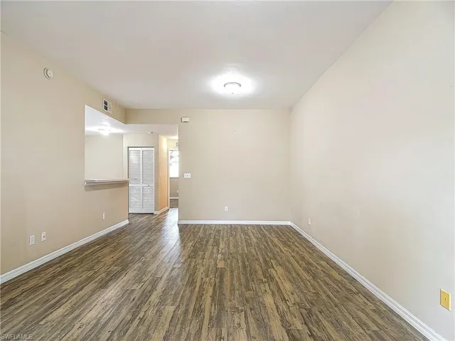 Empty room with dark wood-type flooring
