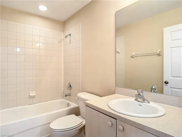 Full bathroom featuring tiled shower / bath, toilet, and vanity