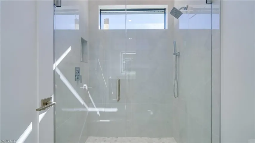 Cabana bath walk-in shower with multiple shower heads.