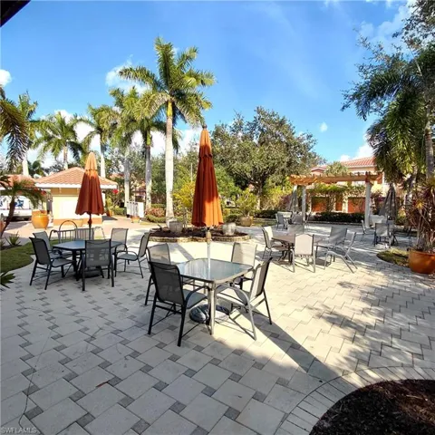 View of the community patio with a pergola and outdoor dining area