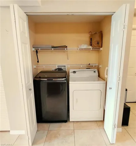 Laundry room featuring light tile patterned floors and separate washer and dryer