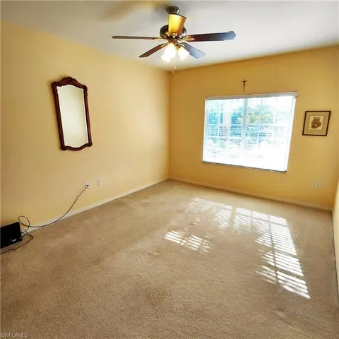 Spare room with carpet floors and a ceiling fan