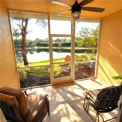 Sunroom featuring a ceiling fan and a water view