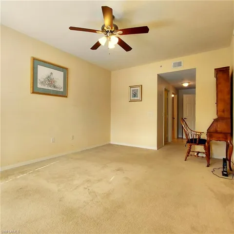 Spare room with light carpet and a ceiling fan