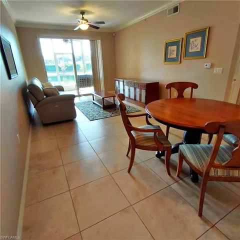 Dining area featuring ornamental molding and light tile patterned flooring