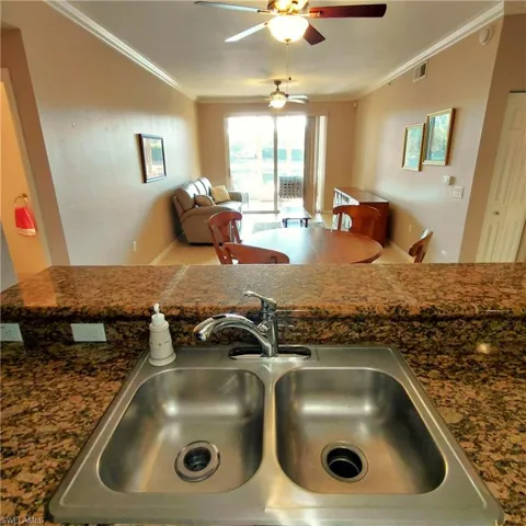 Kitchen view of ornamental molding and a ceiling fan