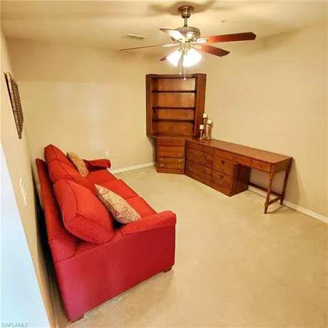 Sitting room featuring ceiling fan and light carpet