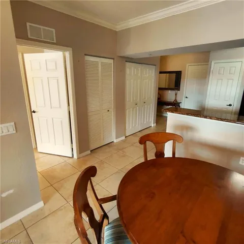 Dining area featuring ornamental molding and light tile patterned floors