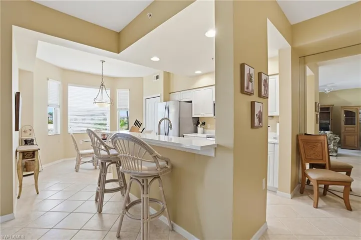 The property features a kitchen with white cabinetry, stainless steel appliances, and a breakfast bar