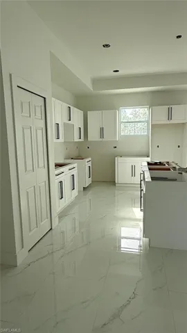 Kitchen with marble finish floor and white cabinets