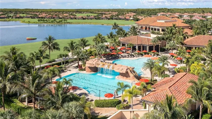 Aerial perspective of suburban area with a nearby body of water and a pool