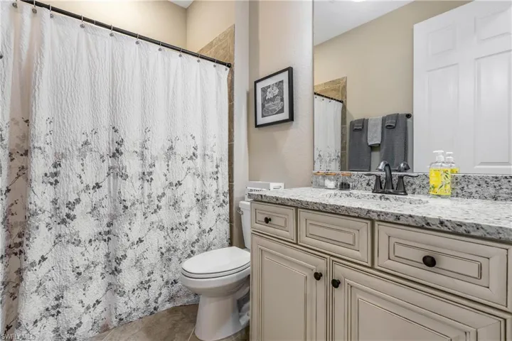 Bathroom featuring vanity, a shower with curtain, and light tile patterned flooring