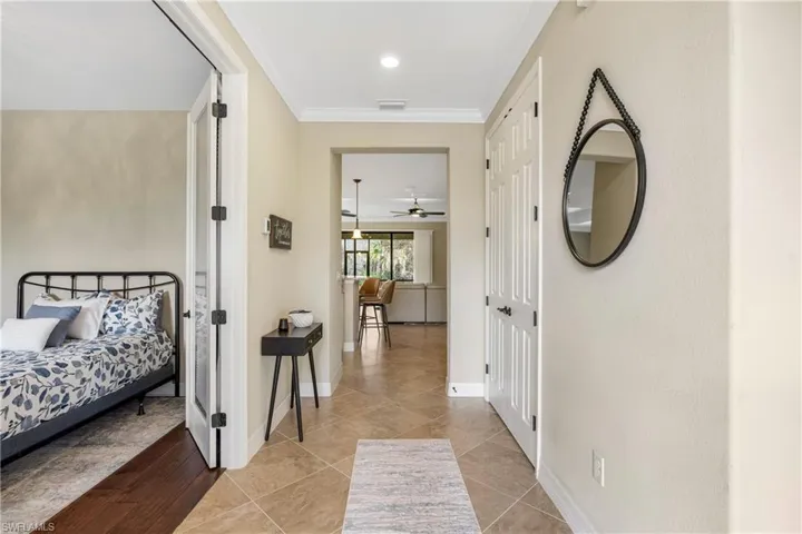 Hall with crown molding and light tile patterned floors