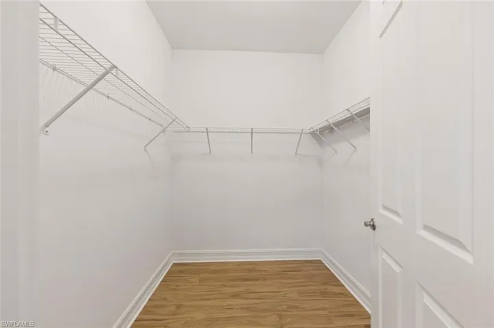Walk in closet with light wood-style floors