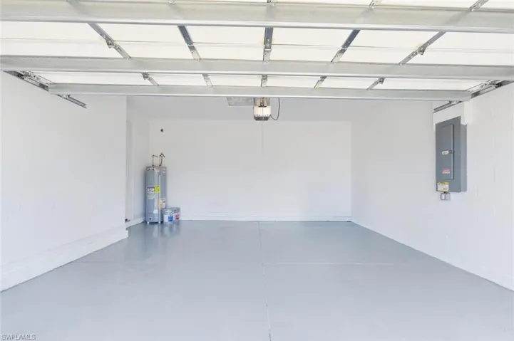 Garage featuring electric panel and water heater