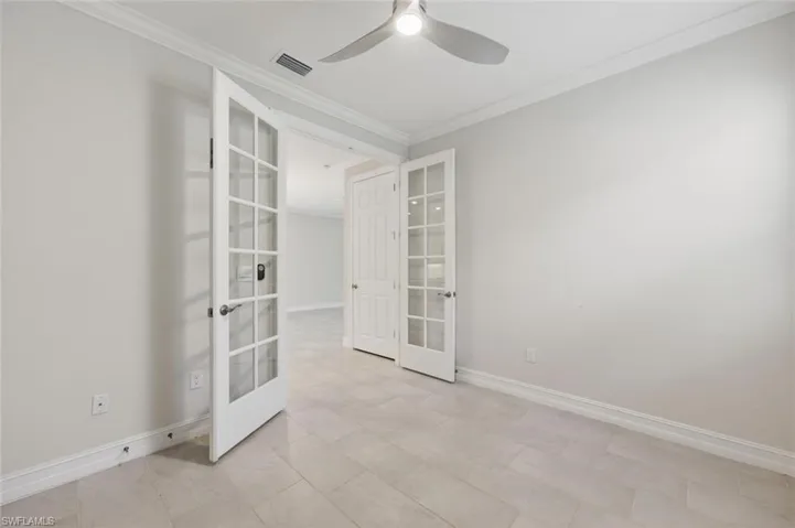 Empty room featuring ornamental molding, french doors, and a ceiling fan