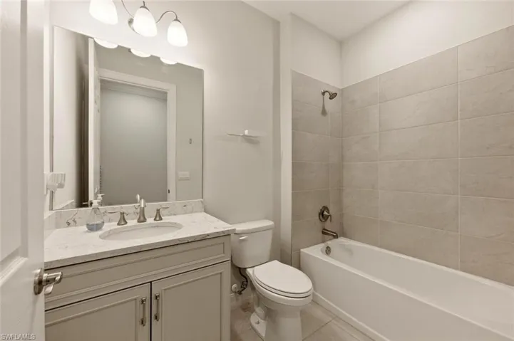 Full bath with vanity, shower / tub combination, and light tile patterned floors