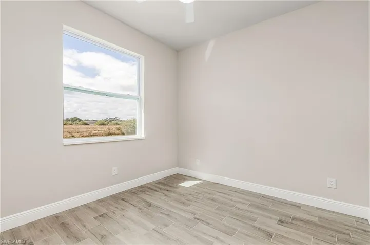 Unfurnished room with ceiling fan and light hardwood / wood-style floors