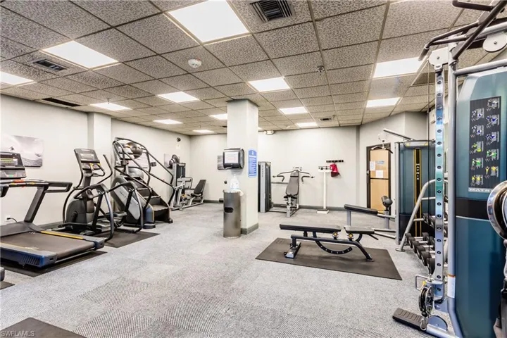 Gym with a paneled ceiling, carpet flooring, and visible vents