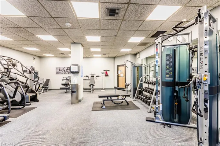 Workout area featuring visible vents, baseboards, and a paneled ceiling