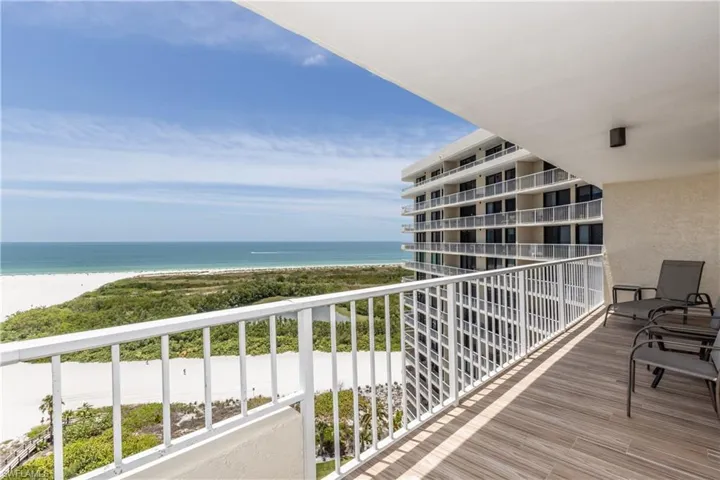 Balcony featuring a view of the beach and a water view
