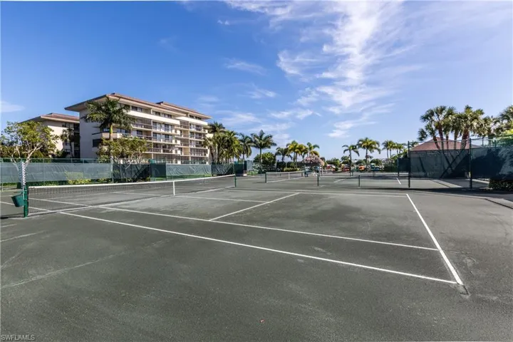 View of tennis court featuring fence
