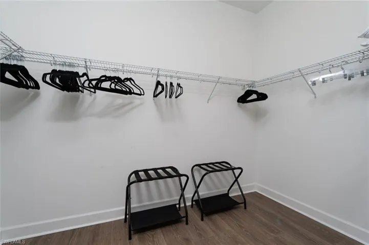 Spacious closet with wire shelving system, white walls, and wood-finish flooring