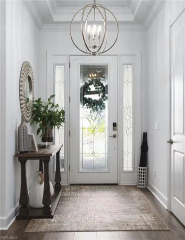 Entryway featuring a decorative transom, sidelight windows, wood-finish flooring, and crown molding