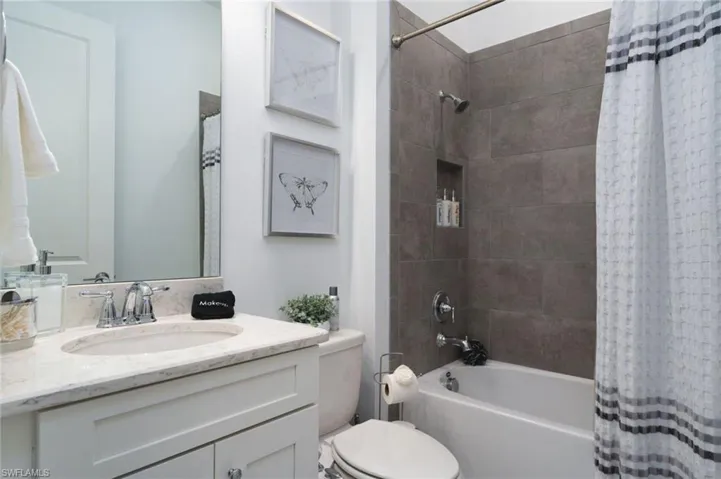 Bathroom featuring a white vanity with an undermount sink, a light-toned countertop, and a chrome faucet