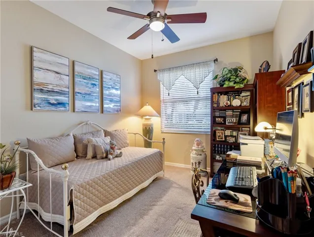 Carpeted bedroom featuring ceiling fan and baseboards