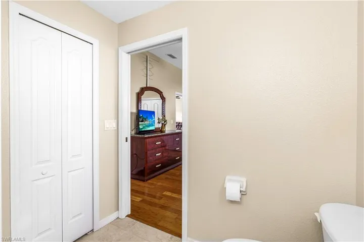Bathroom with tile patterned flooring, visible vents, baseboards, and toilet