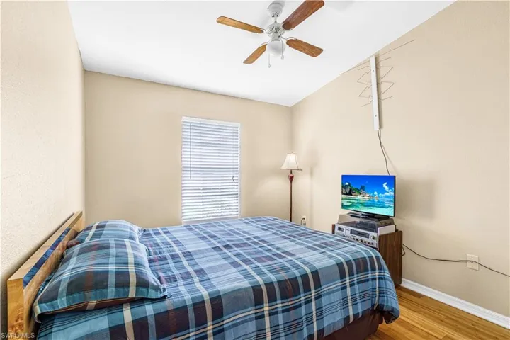 Bedroom featuring ceiling fan, baseboards, and wood finished floors