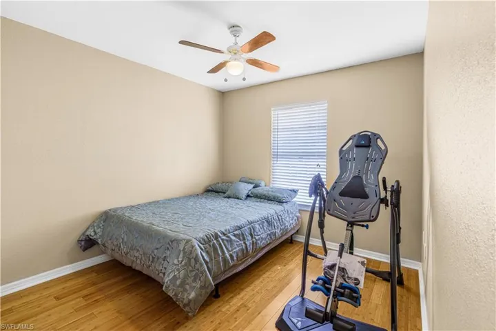 Bedroom with light wood-style flooring, baseboards, and a ceiling fan