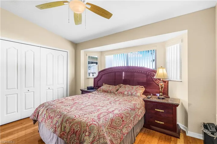 Bedroom featuring light wood-type flooring, a closet, baseboards, and a ceiling fan