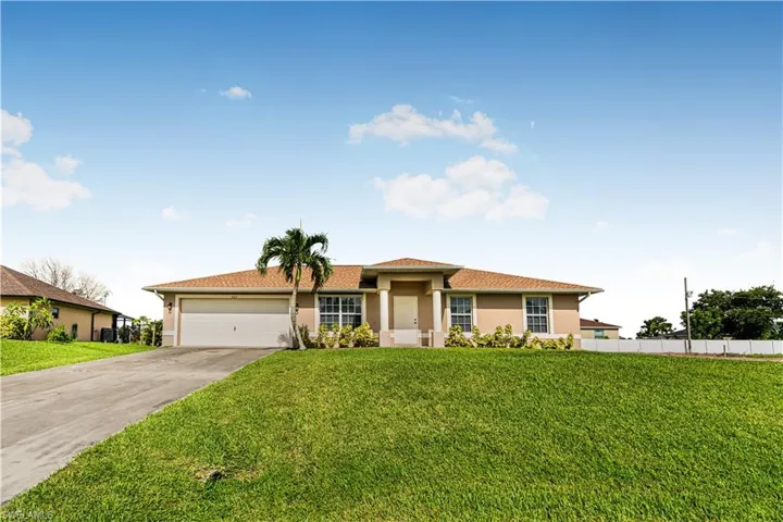 View of front facade featuring concrete driveway, stucco siding, an attached garage, a front yard, and fence