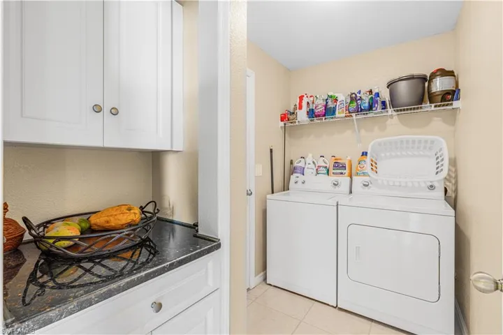Laundry area featuring light tile patterned floors, washer and clothes dryer, and laundry area