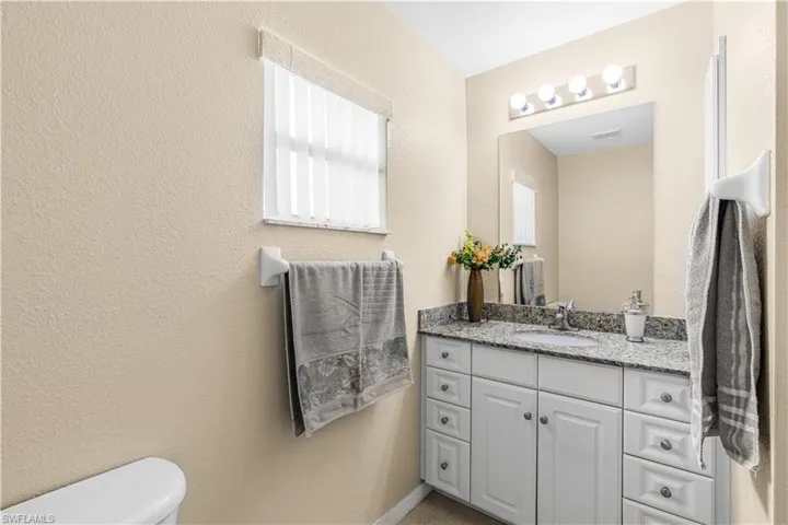 Bathroom with vanity, visible vents, and toilet
