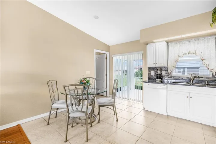 Dining area featuring light tile patterned floors, baseboards, vaulted ceiling, and plenty of natural light