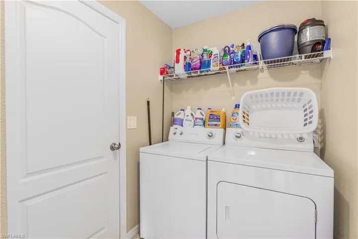 Clothes washing area featuring washing machine and clothes dryer and laundry area