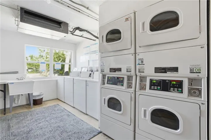 Community laundry room featuring stacked washing machine and dryer