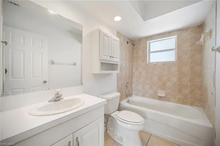Bathroom with vanity, visible vents, tile patterned flooring, shower / bath combination, and toilet