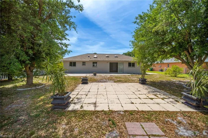 Back of property with stucco siding and a patio