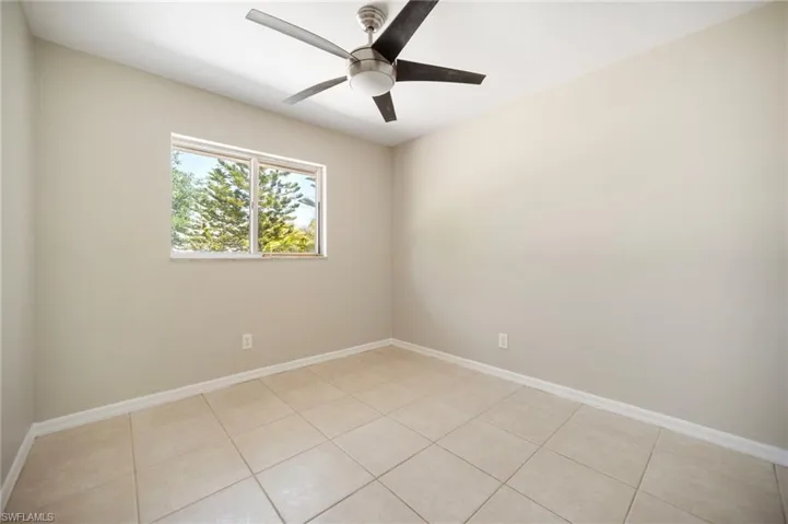 Bedroom #2 with light tile patterned flooring, a ceiling fan, and baseboards