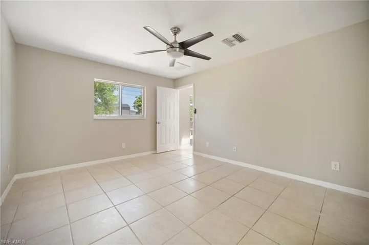 Unfurnished room featuring light tile patterned floors, baseboards, visible vents, and ceiling fan