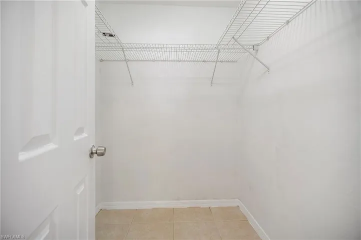 Ensuite Walkin closet with light tile patterned floors