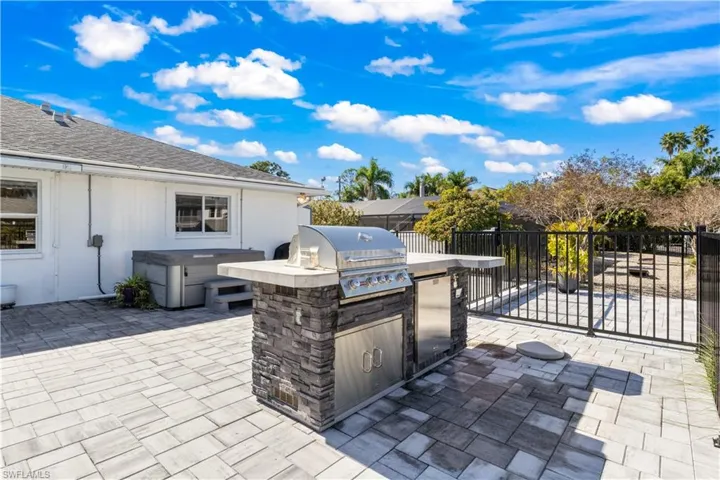 An entertainer’s amphitheater featuring resort-scale pool, standalone spa, and gourmet outdoor kitchen.