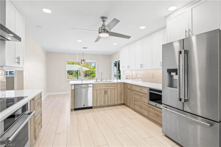 Stunning chef’s kitchen with shaker cabinetry, oversized island, quartz countertops, and premium JennAir appliances.