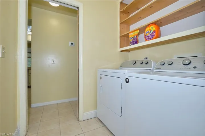 Washroom with separate washer and dryer and light tile floors